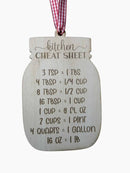 A wooden mason-jar-shaped kitchen cheat sheet ornament with engraved measurement conversions and a red-and-white gingham ribbon hanging from the top.